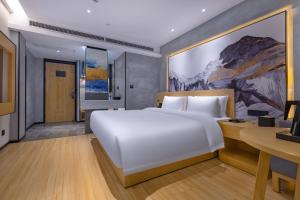 温州途客中国酒店（温州汽车南站店）的卧室配有一张白色大床和一张书桌