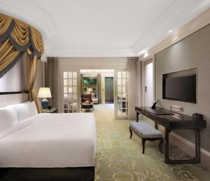成都成都环球中心天堂洲际大饭店的一间卧室配有一张床、一张书桌和一台电视