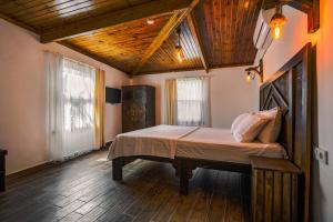 切什梅Belong Butik Otel的铺有木地板的客房设有一间带大床的卧室