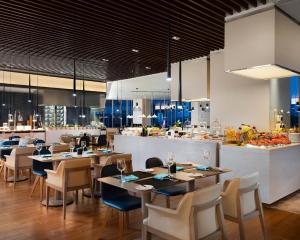 杭州杭州滨江世融艾美酒店的一间带桌椅的餐厅和一间厨房