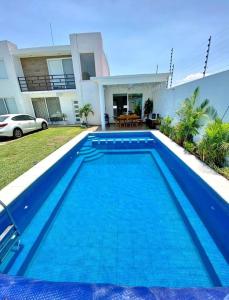Los LimonesCasa con alberca climatizada en Cuautla Morelos的房子前面的蓝色游泳池