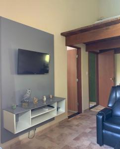里奥克拉鲁chácara Fg 1的客厅设有壁挂式电视和椅子