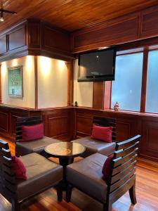 蒙泰韦尔德哥斯达黎加特拉普蒙特维多家庭旅舍的一间设有两把椅子、一张桌子和一台电视的房间