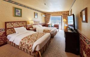 束草市KensingtonHotel Seorak的酒店客房设有两张床和电视。