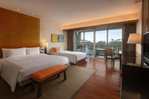 万宁石梅湾艾美度假酒店（三亚机场穿梭巴士+每日免费亲子活动）的酒店客房设有两张床和一个阳台。