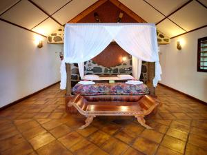 Kani Keli茂瑞花园酒店的一间设有一张天蓬床的房间