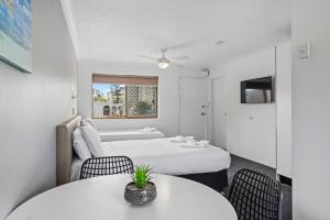 黄金海岸Gold Coast Inn的酒店客房,设有两张床和两张桌子