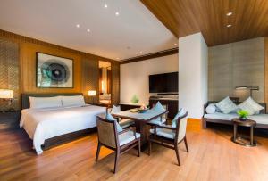 万宁石梅湾艾美度假酒店（三亚机场穿梭巴士+每日免费亲子活动）的卧室配有一张床和一张桌子及椅子
