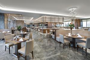 青岛青岛国际机场君廷酒店的餐厅的 ⁇ 染,配有桌椅