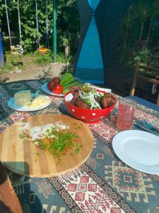 SanainTereza glamping的桌上放有盘子和碗的食物
