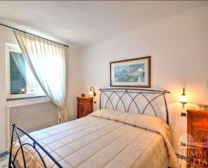 普莱伊亚诺Villino Blu的一间卧室设有一张床和一个窗口