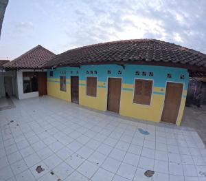 日惹Tamasya Living Malioboro Family Only的蓝色和黄色的建筑,设有门和瓷砖庭院