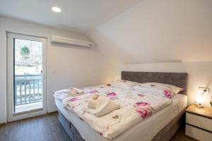 博希尼Apartment CRYSTAL AURA 1的一间卧室配有一张带粉红色鲜花的大床