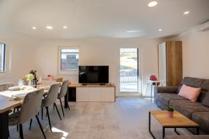 博希尼Apartment CRYSTAL AURA 1的客厅配有桌子、沙发和电视。