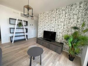 利尼亚诺萨比亚多罗MARE Appartamento 8的客厅配有平面电视和桌子。