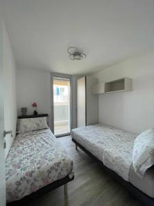 利尼亚诺萨比亚多罗MARE Appartamento 8的一间卧室设有两张床和窗户。