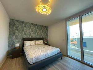 利尼亚诺萨比亚多罗MARE Appartamento 8的一间卧室设有一张床和一个大窗户