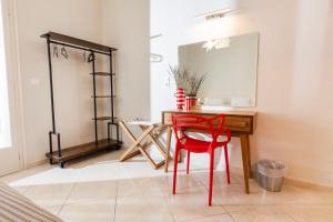 斯基亚索斯镇Mondrian Guest House的配有桌子、红色椅子和镜子的房间