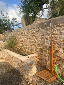 圣卡洛斯Agroturismo rural Can Prats的石墙淋浴和木凳
