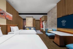 长沙长沙梅溪湖英迪格酒店的一间酒店客房,设有两张床和电视