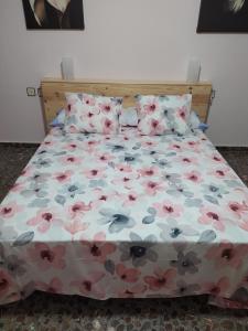 阿尔阿马德穆尔西亚Casa del carpintero的一张带花卉棉被和两个枕头的床