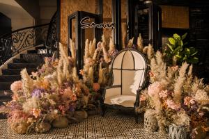 岘港岘港萨诺瓦酒店的坐在一束植物前面的椅子