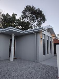 布里斯班Immaculate 2-Beds Entire House Chermside Brisbane的白色的房子,设有车库