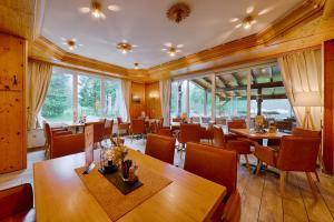 腓特烈罗达Tanzbuche的餐厅设有木桌和椅子以及大窗户。