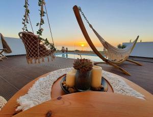 卡尔帕索斯Tramonto Luxury Villa No1- Breathtaking sunset view的露台上配有一张桌子、蜡烛和椅子