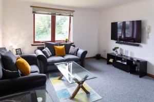 邓弗姆林Bothwell Court Apartments的客厅配有两张沙发和一台电视机