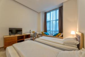 兹拉蒂博尔Apartments Kulturni centar Zlatibor的酒店客房设有两张床和电视。