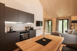 毛特恩多夫Rest Apartments & Suiten的厨房以及带木桌的起居室。