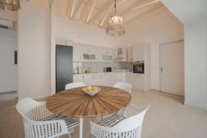 阿凯松Kavo Seaside Luxury Apartment的厨房以及带木桌和椅子的用餐室。