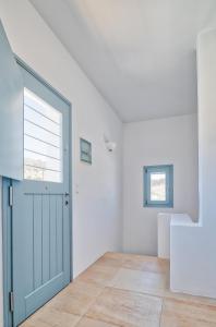 安迪帕罗斯岛Villa Afroditi的一间白色的房间,设有蓝色的门和楼梯