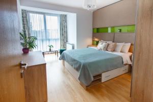 克卢日-纳波卡Gold Class Apartments AMS的一间卧室配有一张带绿色床头板的床