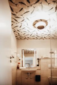 瓦尔多夫Villa Bosco - Digitales Boutiquehotel的浴室设有天花板,上面有鱼画