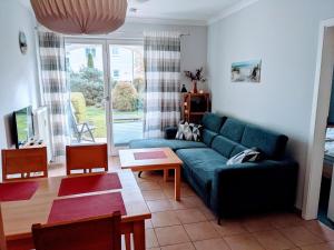奥斯赛拜-屈隆斯博恩Appartmenthaus Ostseestrand的客厅配有蓝色的沙发和桌子