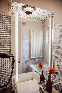 瓦尔多夫Villa Bosco - Digitales Boutiquehotel的一间带水槽和镜子的浴室