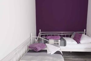 比克Apartments in Bük - Nordtransdanubien 44085的一间卧室设有紫色墙壁和一张带紫色枕头的双层床
