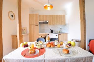 贝尔热拉克Le Boho - Charmant T3 - gare à 5 min à pieds的厨房里摆放着羊角面包和水果的桌子