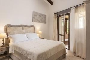 切尔沃港Relais Villa Carola的白色的卧室设有床和窗户