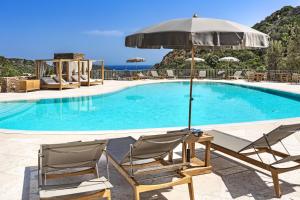 切尔沃港Relais Villa Carola的游泳池旁的一对椅子和一把遮阳伞