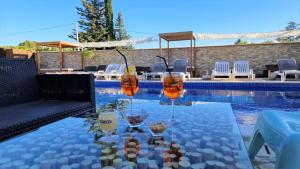 格拉沃松马斯阿曼迪尔酒店的游泳池旁的桌子和玻璃杯