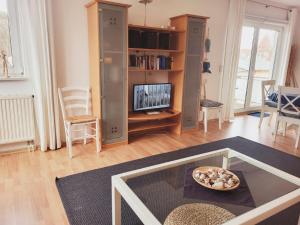 奥斯赛拜-屈隆斯博恩Appartementhaus Ulmenhof的客厅配有桌子和电视