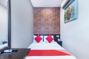 八打灵再也OYO 876 Hotel Sanctuary的客房配有红色枕头的床。