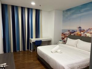 吉隆坡Summer Suites KLCC By Whollmark的一间卧室配有一张床和一张书桌