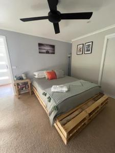 天鹅山Kima Quarters的一间卧室配有一张带吊扇的床