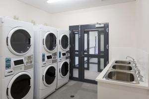 弗里曼特YHA Fremantle Prison的洗衣房配有3台洗衣机和水槽