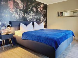 奥斯赛拜-屈隆斯博恩Appartementanlage Ostseeblick的一间卧室配有一张带蓝色毯子的大床