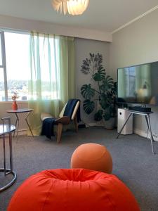 惠灵顿Central Nest- view & style的客厅配有大屏幕电视和家具。